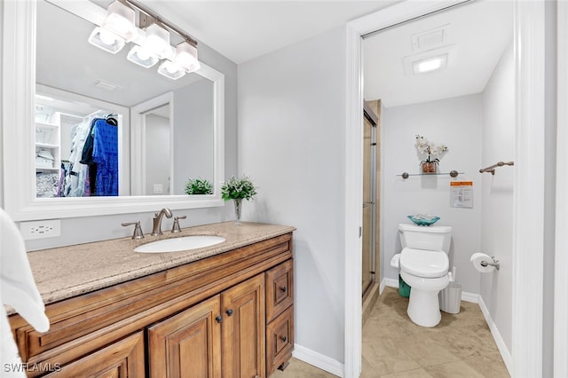 bathroom with toilet, vanity, and a shower with shower door