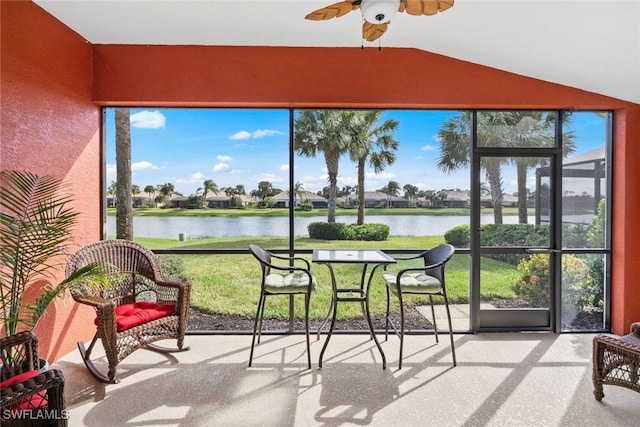 sunroom featuring ceiling fan, a water view, and vaulted ceiling