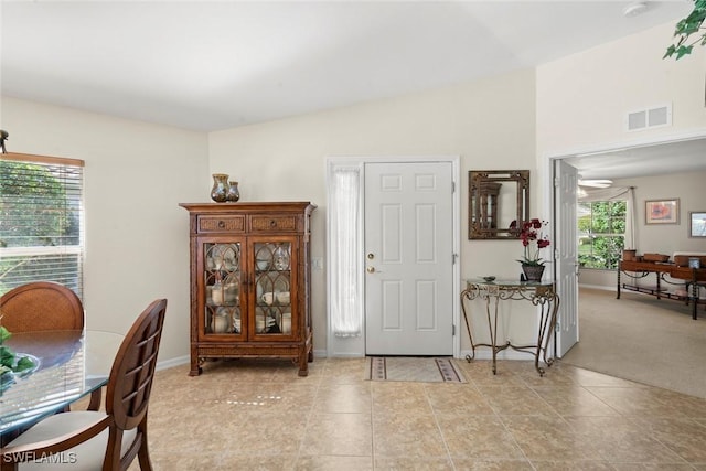 carpeted entrance foyer with ceiling fan and lofted ceiling