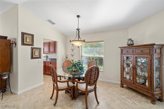 tiled dining space featuring lofted ceiling