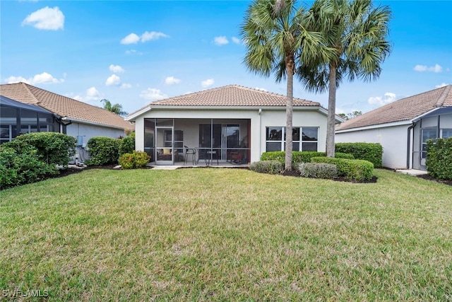 back of house featuring a lawn and a sunroom