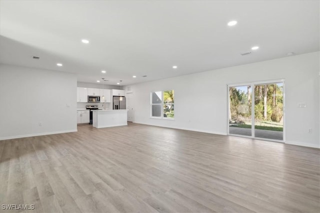 unfurnished living room featuring light hardwood / wood-style floors and a healthy amount of sunlight