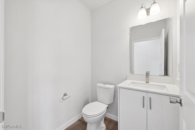 bathroom featuring vanity, hardwood / wood-style flooring, and toilet