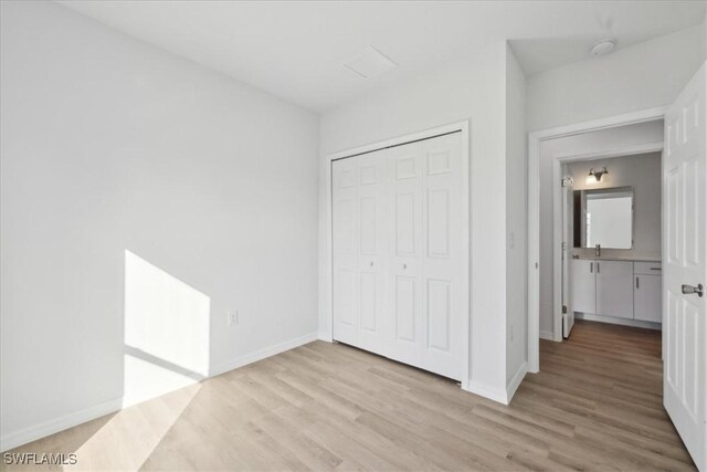 unfurnished bedroom featuring light hardwood / wood-style floors and a closet