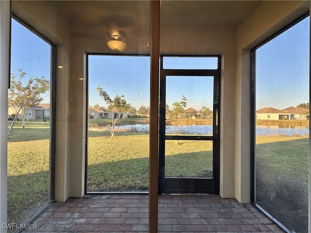 unfurnished sunroom featuring a water view