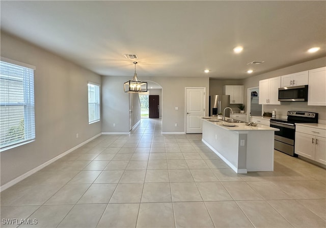 kitchen featuring sink, an island with sink, pendant lighting, white cabinets, and appliances with stainless steel finishes