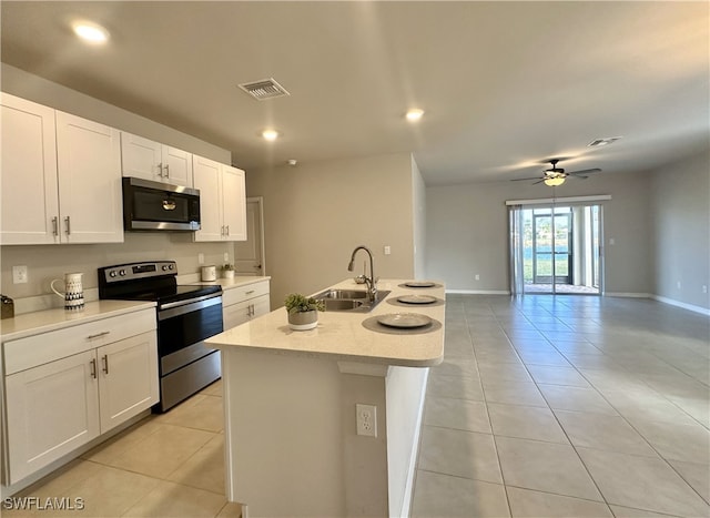 kitchen featuring ceiling fan, sink, stainless steel appliances, an island with sink, and white cabinets