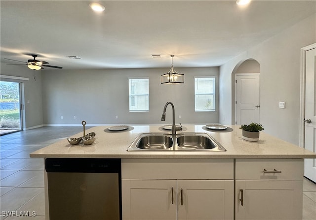 kitchen with stainless steel dishwasher, sink, a center island with sink, white cabinets, and light tile patterned flooring