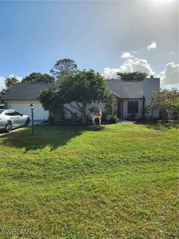 view of front of property with a front yard and a garage