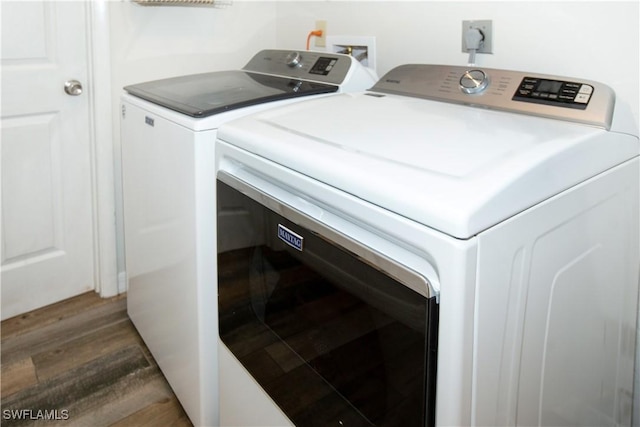 laundry room with dark hardwood / wood-style floors and washing machine and clothes dryer