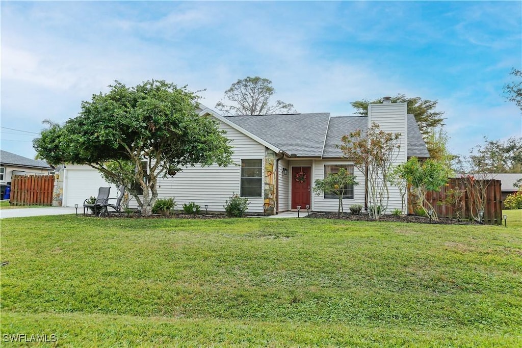 ranch-style home with a garage and a front lawn