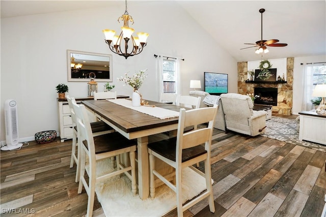 dining room featuring high vaulted ceiling, dark hardwood / wood-style floors, a wealth of natural light, and a fireplace