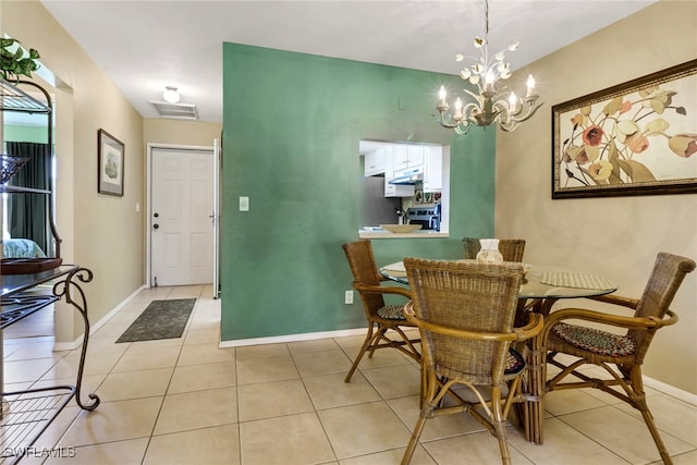 dining space with light tile patterned floors and a chandelier