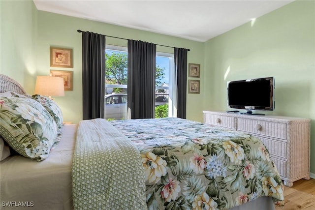 bedroom with light hardwood / wood-style floors and access to outside