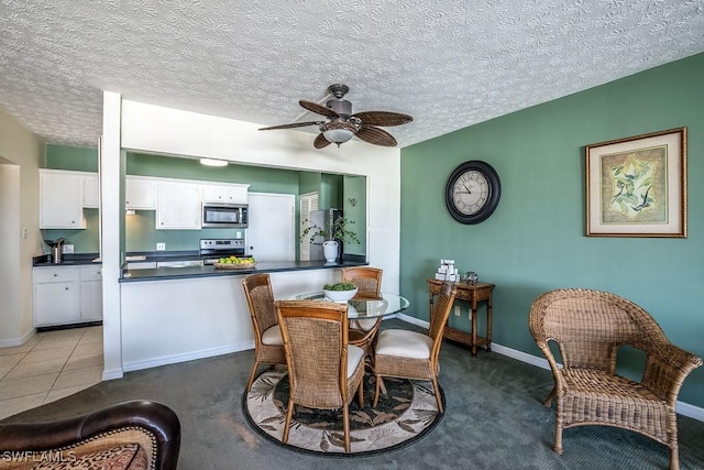 dining room featuring a textured ceiling, light colored carpet, and ceiling fan