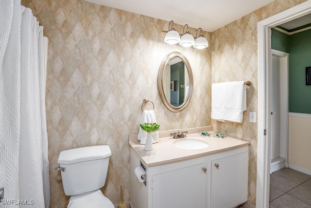 bathroom with toilet, vanity, and tile patterned floors