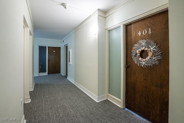 hall featuring crown molding and dark carpet