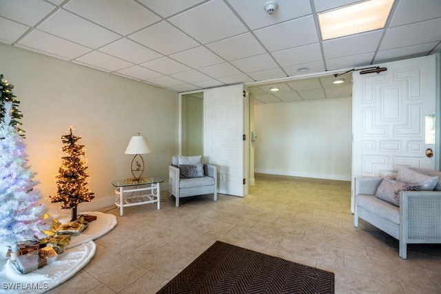 sitting room with a drop ceiling and light tile patterned floors