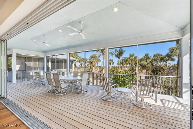 unfurnished sunroom with ceiling fan and lofted ceiling