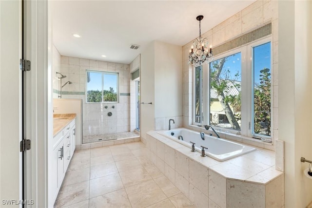 bathroom with tile patterned flooring, vanity, an inviting chandelier, and separate shower and tub