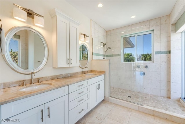 bathroom with tile patterned floors, vanity, and tiled shower