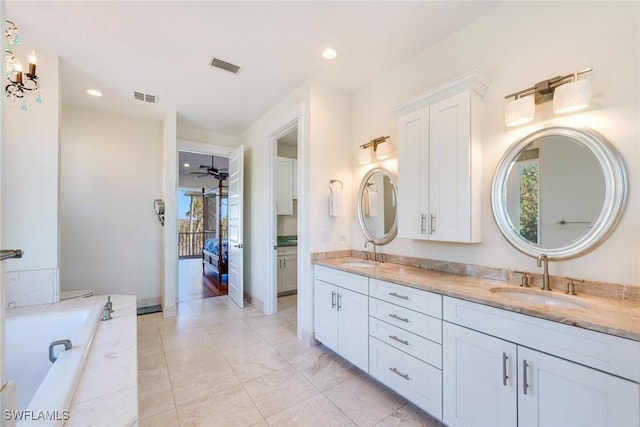 bathroom featuring tile patterned flooring, ceiling fan, tiled tub, and vanity