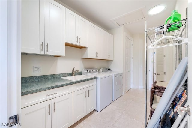 washroom with cabinets, light tile patterned floors, washing machine and dryer, and sink