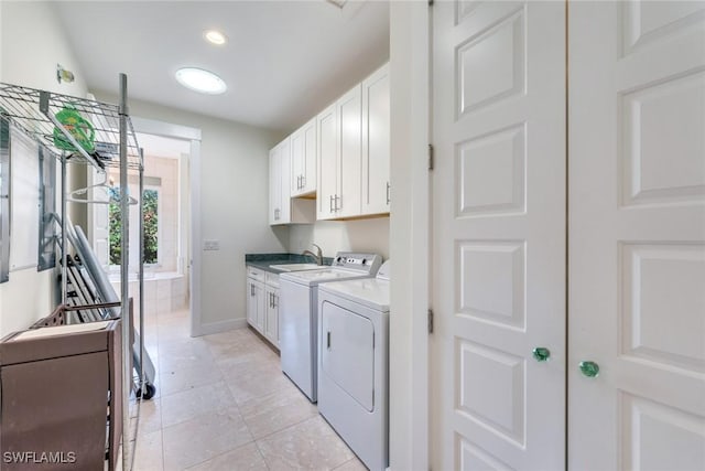 clothes washing area featuring light tile patterned flooring, cabinets, sink, and washing machine and clothes dryer