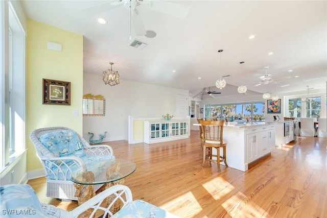 interior space with decorative light fixtures, white cabinetry, and light hardwood / wood-style flooring