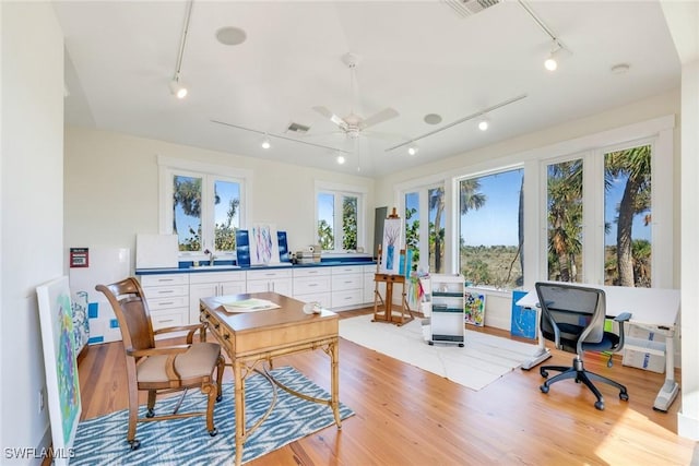 office area with plenty of natural light, ceiling fan, track lighting, and light hardwood / wood-style flooring