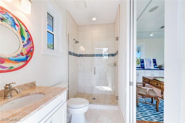 bathroom featuring tile patterned flooring, vanity, toilet, and a shower with shower door