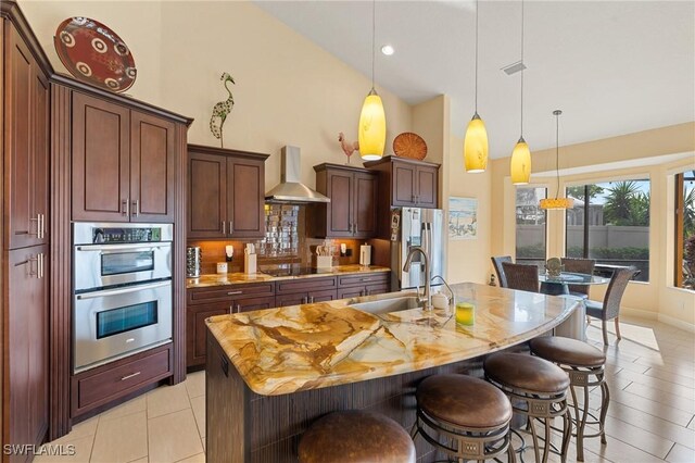 2108 SW 38th Ter, Cape Coral, FL 33914 - kitchen with wall chimney range hood, high vaulted ceiling, a sink, stainless steel appliances, and a kitchen breakfast bar