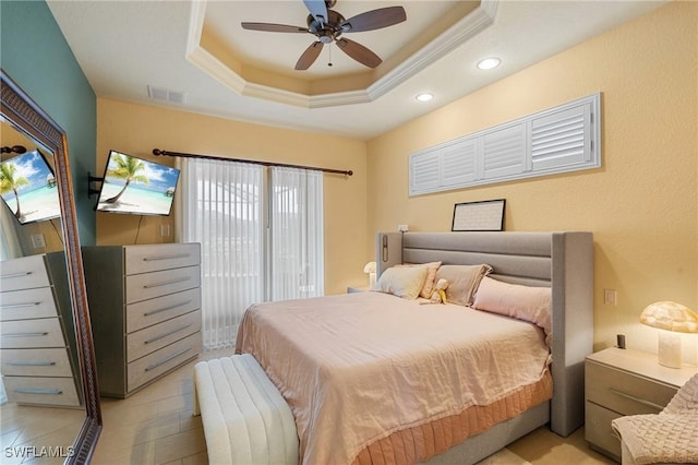 bedroom featuring ceiling fan, crown molding, and a tray ceiling