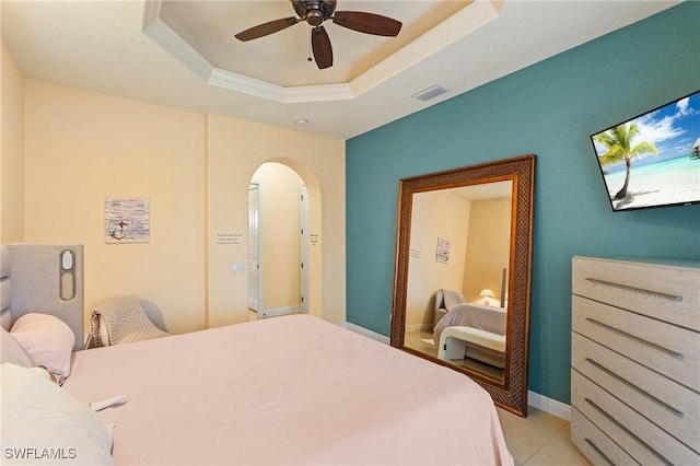 2108 SW 38th Ter, Cape Coral, FL 33914 - bedroom featuring arched walkways, a tray ceiling, a ceiling fan, and light tile patterned flooring