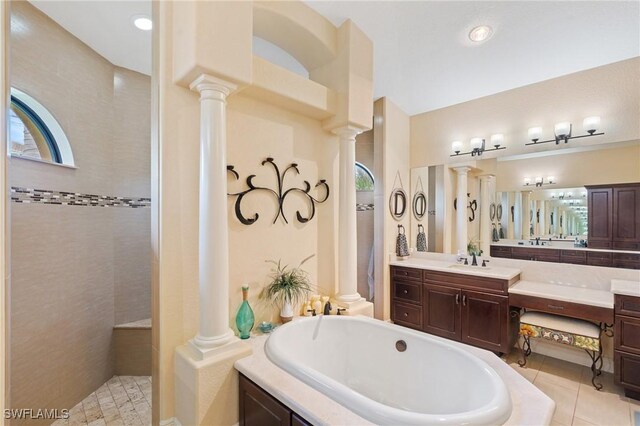 bathroom with a tile shower, tile patterned flooring, vanity, and ornate columns