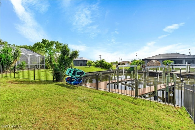 view of yard featuring glass enclosure, a dock, and a water view