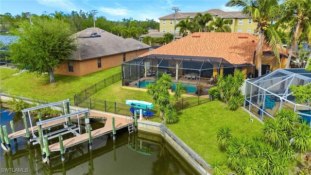 exterior space with a water view, glass enclosure, and a yard