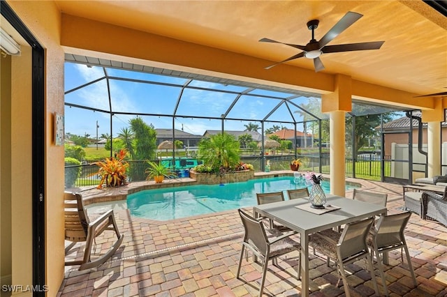 view of pool with glass enclosure, a water view, and a patio