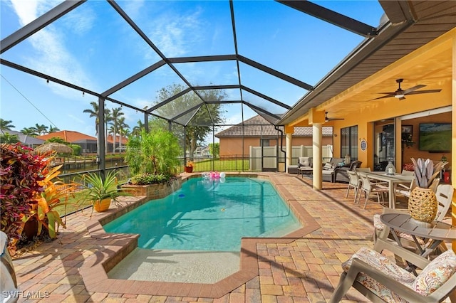 view of swimming pool with a patio, ceiling fan, and glass enclosure