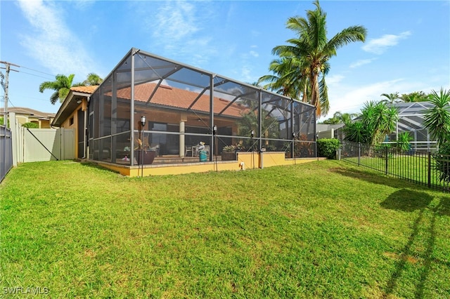 back of house with a lanai and a lawn