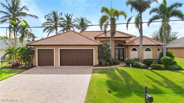 mediterranean / spanish-style house featuring a garage and a front lawn