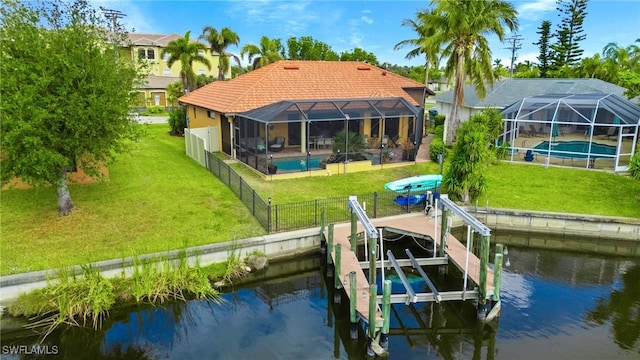 dock area with glass enclosure, a water view, and a yard