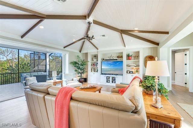 living room with lofted ceiling with beams and light hardwood / wood-style flooring