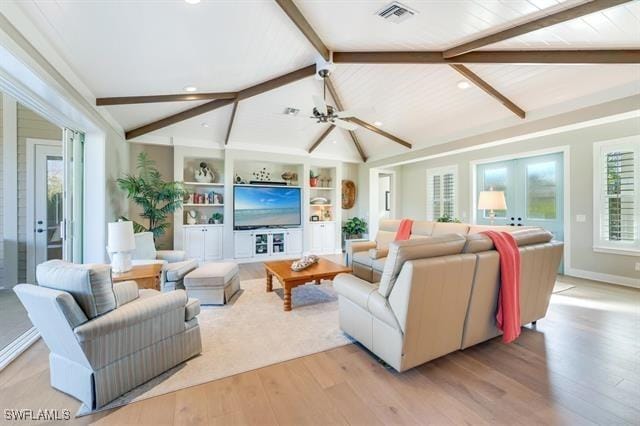 living room featuring vaulted ceiling with beams, ceiling fan, french doors, and light wood-type flooring