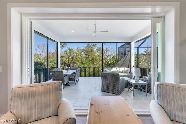 sunroom / solarium featuring plenty of natural light and ceiling fan