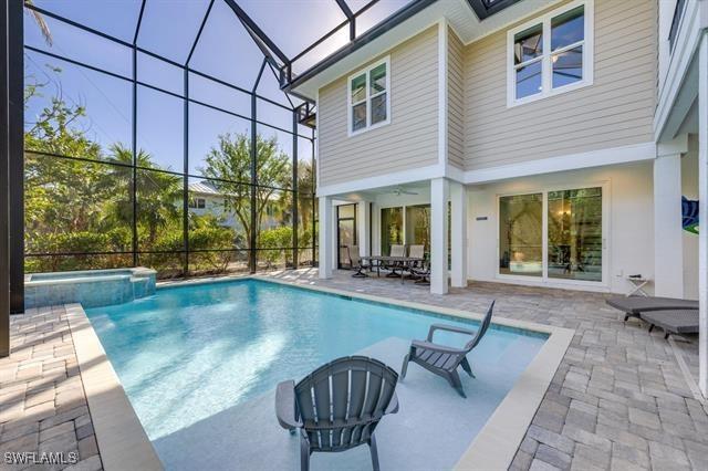 view of swimming pool featuring a lanai, an in ground hot tub, ceiling fan, and a patio