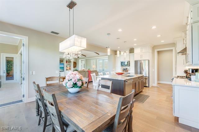 dining space featuring a chandelier, light wood-type flooring, and sink