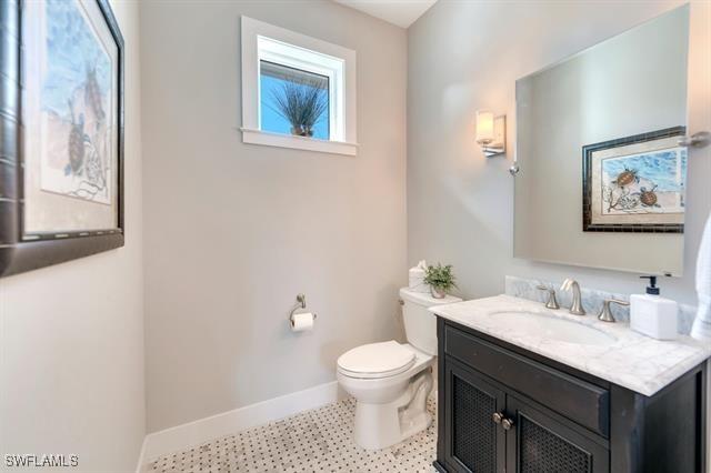 bathroom featuring plenty of natural light, toilet, and vanity