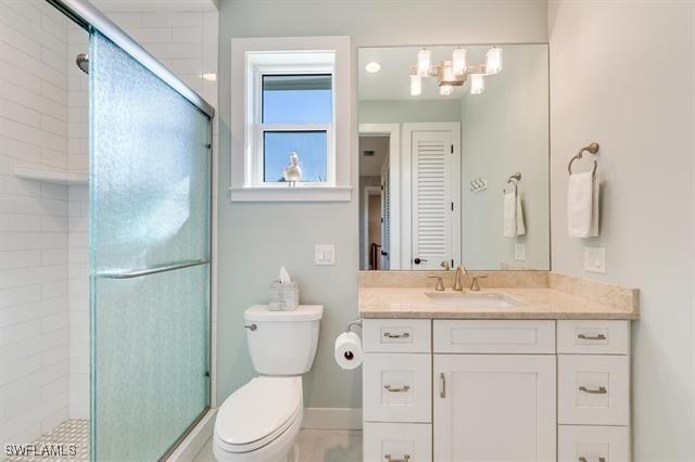 bathroom featuring walk in shower, vanity, and toilet