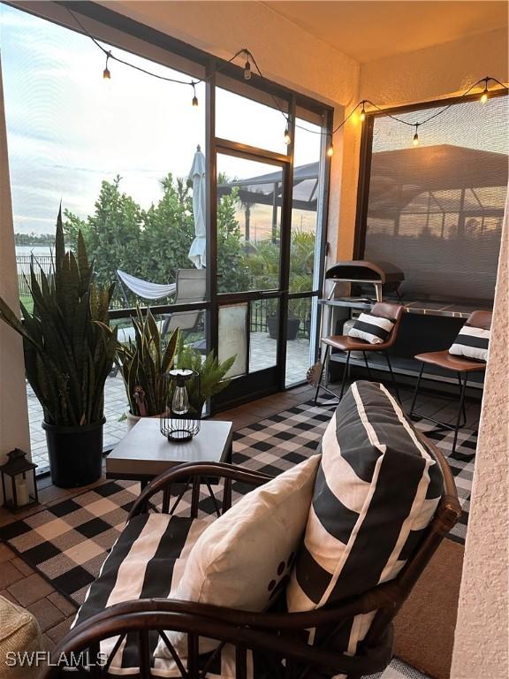 sunroom featuring a wealth of natural light and a water view